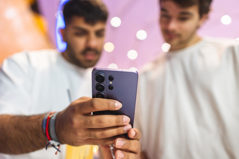 Two people using a Samsung Galaxy phone before selling it for cash near Raleigh, NC