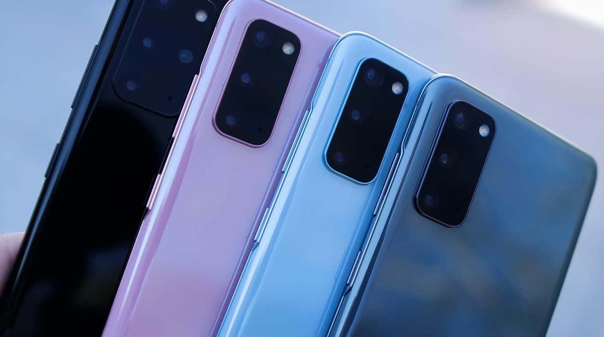 Four Samsung Galaxy phones fanned out in different colors, held up against a bright background